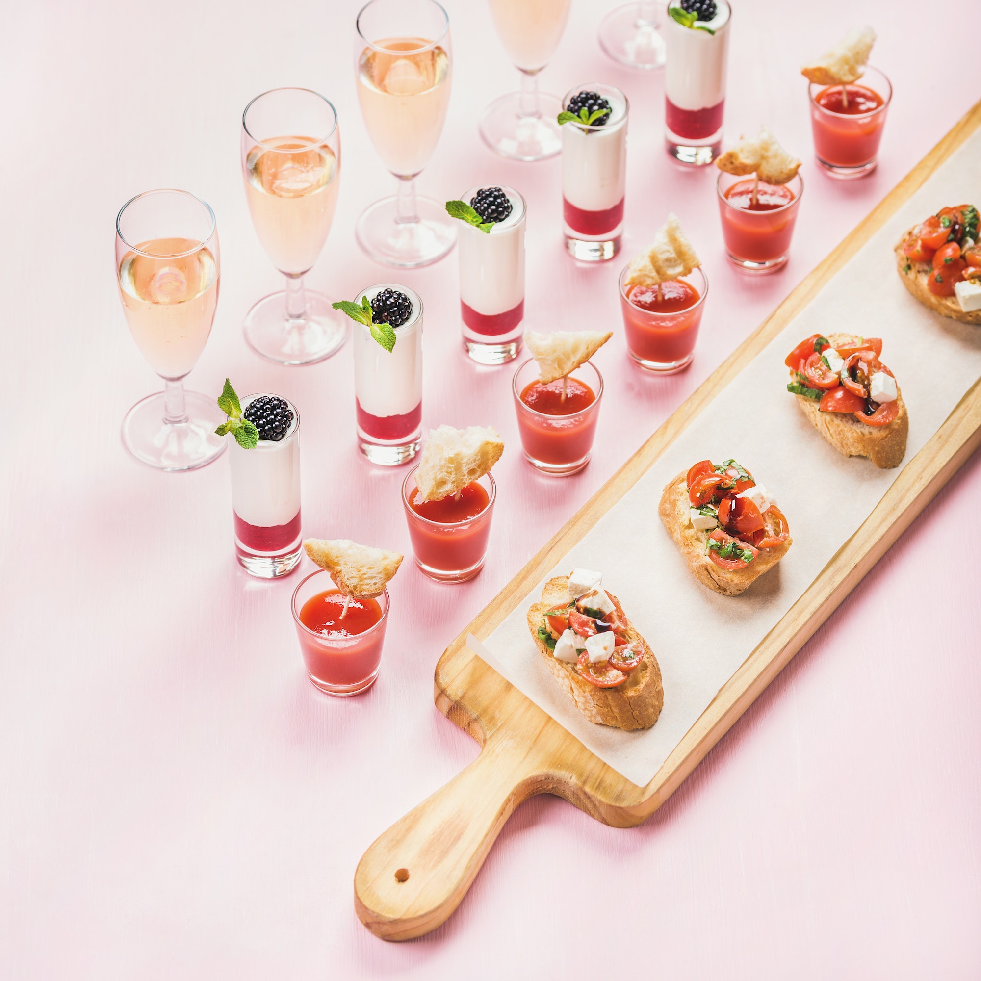 Catering, banquet food concept over pastel pink background