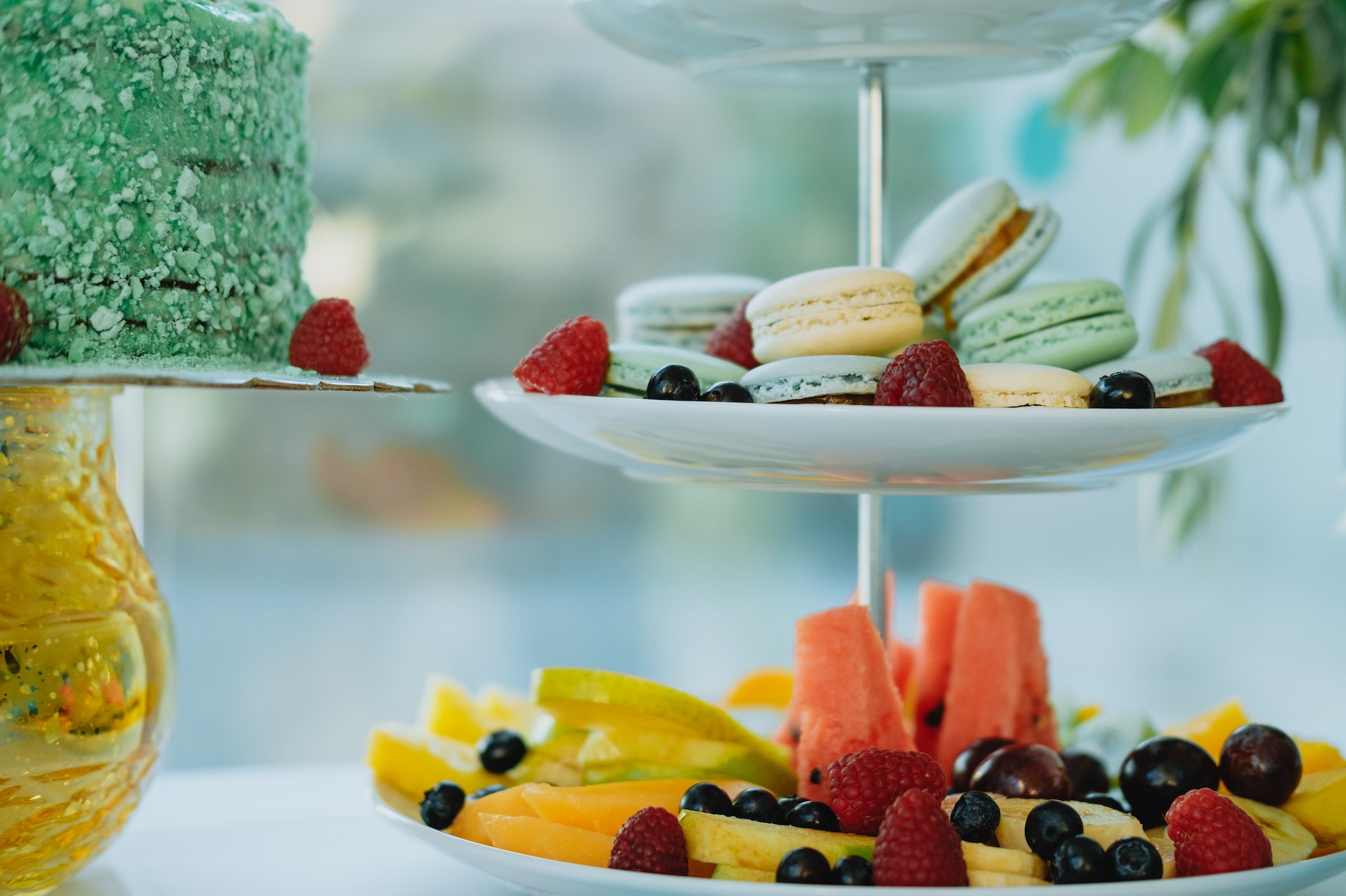 Sweet table with colorful macaroons, fruits and cake